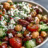 Hearty Greek Bean Salad served in a white bowl, drizzled with zesty lemon-oregano dressing and garnished with fresh parsley and dill.