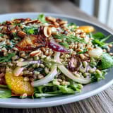 Farro Salad Bowl with Fennel, Oranges & Almonds served fresh in a white bowl, garnished with chopped fennel fronds.