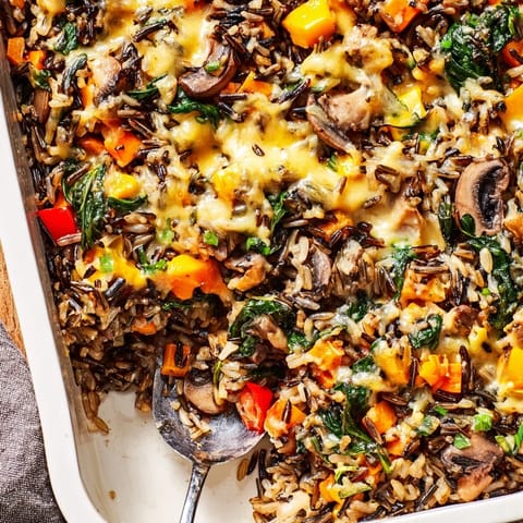 Golden-brown Wild Rice Casserole bubbling in a baking dish, served as a hearty vegetarian side dish.