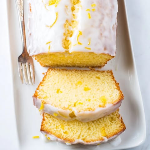 Freshly baked Lemon Pound Cake cooling on a wire rack, showcasing a golden crust and tangy lemon glaze.