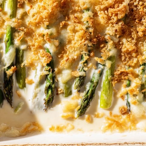 Creamy Asparagus Casserole served as a hearty vegetarian side dish alongside roasted chicken on a rustic dinner table.