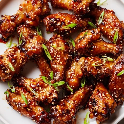 Asian Sticky Wings glazed with a sweet soy-ginger sauce, served alongside steamed rice and quick pickled vegetables for dinner.