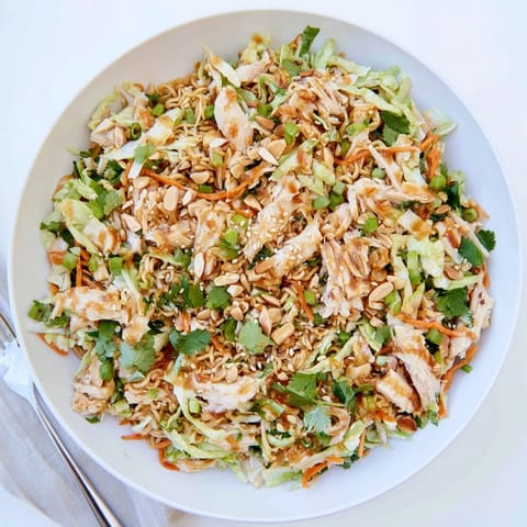 Vibrant Crunchy Ramen Chicken Salad with toasted almonds, carrots, and fresh cilantro, ideal for a quick lunch or potluck.  