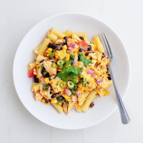 Savory Crispy Chicken Burrito Pasta topped with fresh cilantro, green onions, and a dollop of sour cream.  