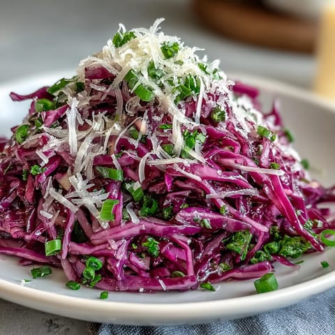 Freshly shredded red cabbage with crisp apple slices and shaved Parmesan, tossed in tangy vinaigrette for a vibrant coleslaw.