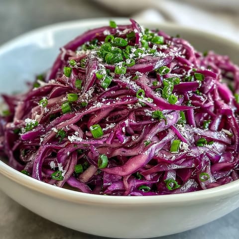 Crunchy Red Cabbage Coleslaw with Apple and Parmesan served in a rustic white bowl, ready to eat as a side dish.