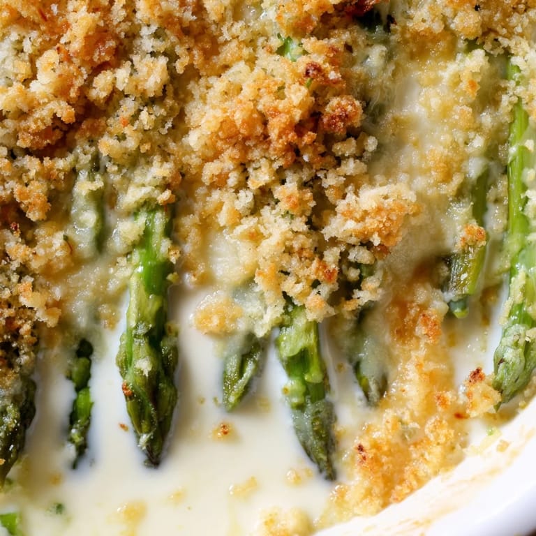 Vibrant green Asparagus Casserole featuring a rich Gruyère cream sauce and a crunchy breadcrumb crust for a comforting bite.
