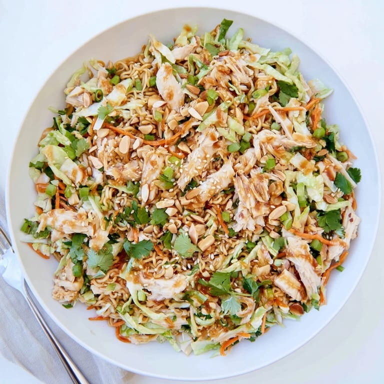 Vibrant Crunchy Ramen Chicken Salad with toasted almonds, carrots, and fresh cilantro, ideal for a quick lunch or potluck.  