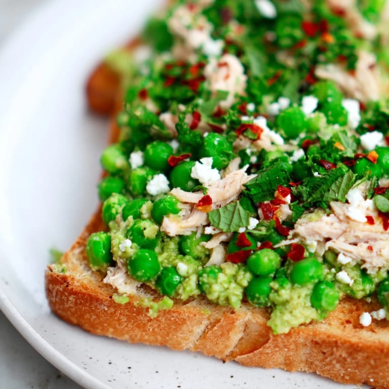 Golden crisp toast topped with savory shredded chicken and vibrant green pea mash, finished with feta.