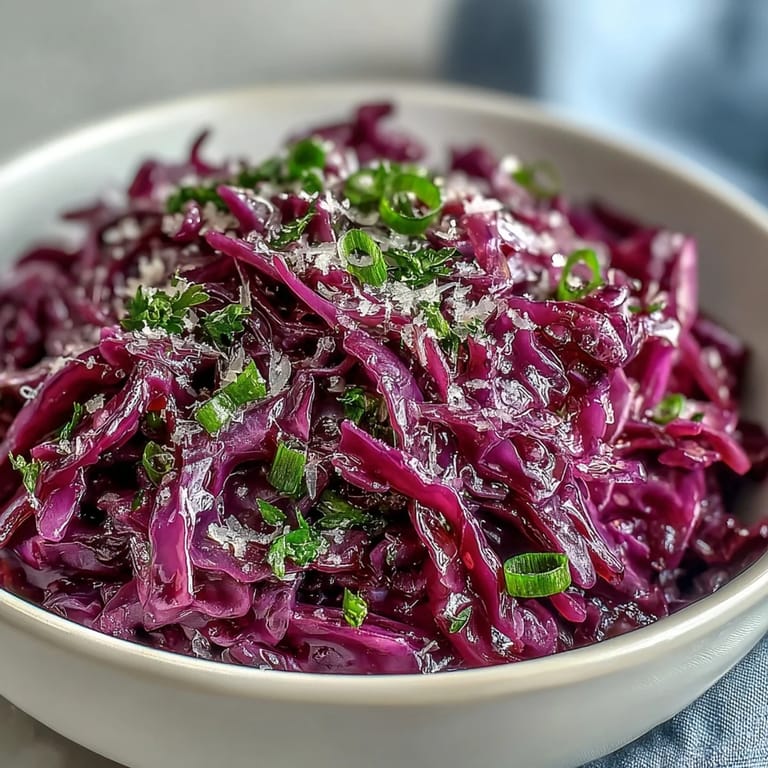 Vivid purple and green salad with julienned apple, savory Parmesan shavings, and fresh parsley garnish on a dark wooden table.